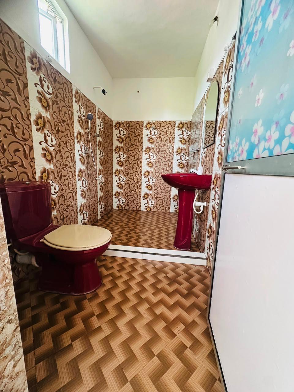 Tiled bathroom with shower, pedestal basin and toilet